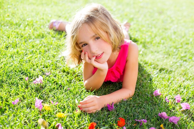 blonde jongen meisje liggend ontspannen in de tuin gras met bloemen