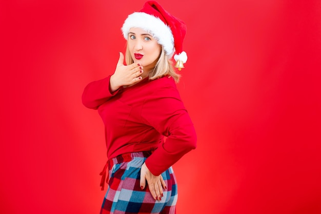 Blonde kerstpyjama staat zijwaarts met haar hand op haar heupen