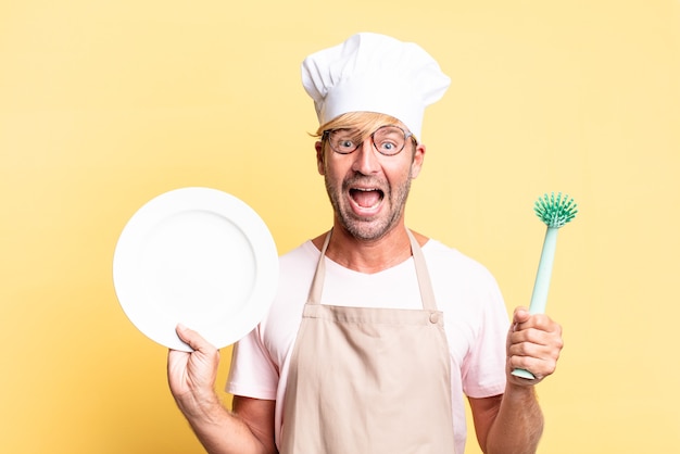 Blonde knappe chef-kok volwassen man met een lege schotel