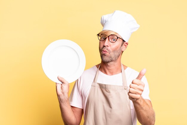 Blonde knappe chef-kok volwassen man met een lege schotel