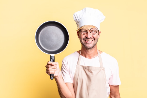 Blonde knappe chef-kok volwassen man met een pan