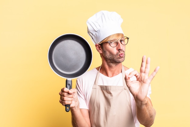 Blonde knappe chef-kok volwassen man met een pan