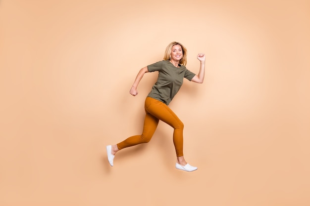 Blonde lady posing against the beige wall