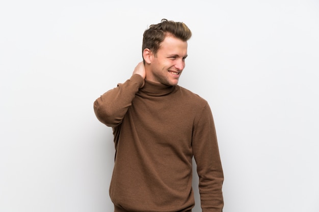 Blonde man over isolated white wall with neckache