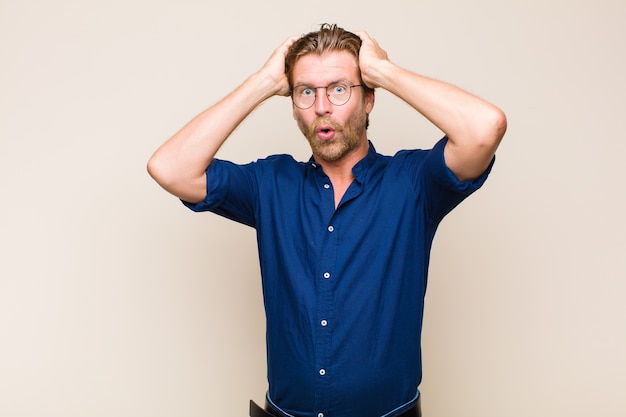 Blonde man looking excited and surprised