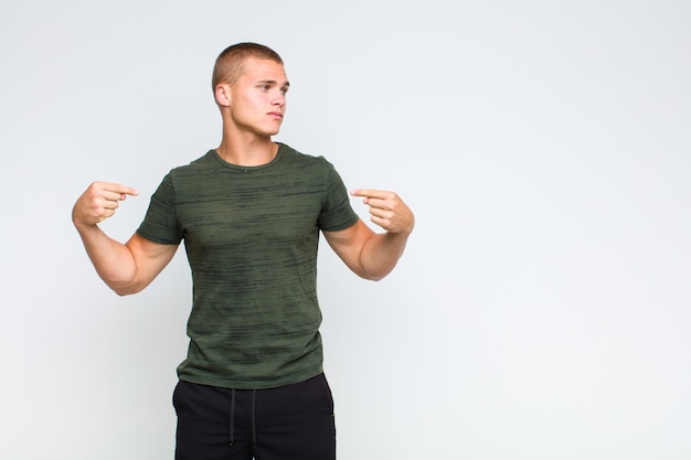 Blonde  man looking proud, positive and casual pointing to chest with both hands