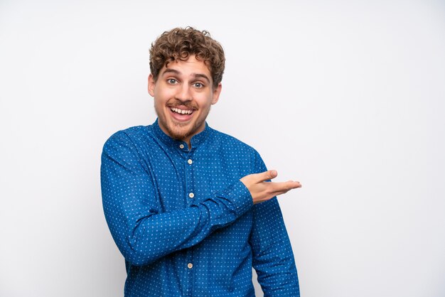 Blonde man met blauw shirt uitbreiding van de handen aan de zijkant voor het uitnodigen om te komen