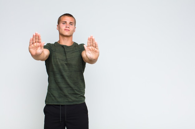 Blonde man saying stop with both open palms