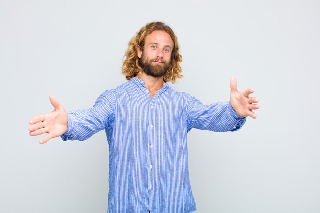 Blonde man smiling and giving a warm hug