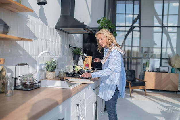 Blonde mature pretty woman cooking in the kitchen