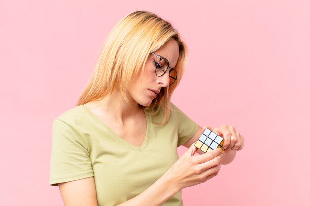 Blonde mooie vrouw die een logisch uitdagingsspel oplost