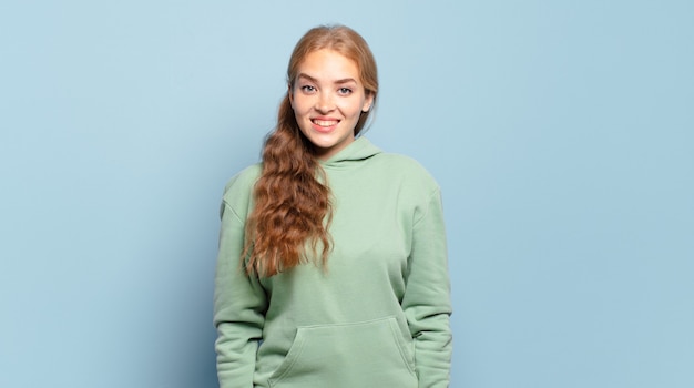 blonde mooie vrouw die er gelukkig en maf uitziet met een brede, grappige, gekke glimlach en ogen wijd open