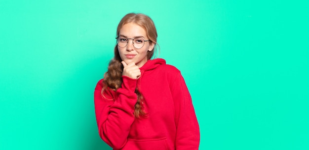 Blonde, mooie vrouw die ernstig, verward, onzeker en attent kijkt, twijfelt tussen opties of keuzes