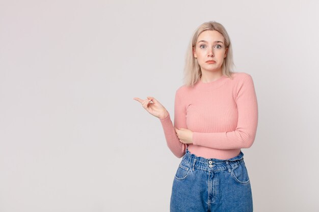 blonde mooie vrouw die haar schouders ophaalt, zich verward en onzeker voelt