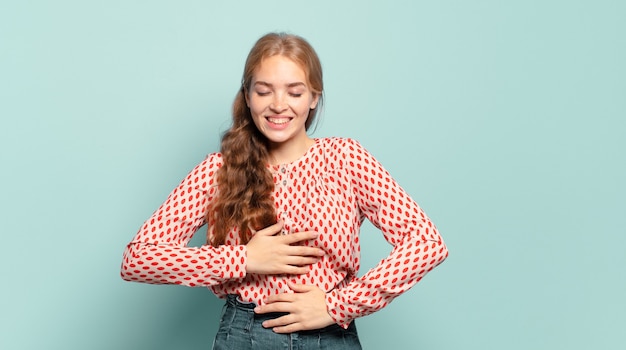 Foto blonde mooie vrouw die hardop lacht om een of andere hilarische grap, zich gelukkig en opgewekt voelt, plezier heeft