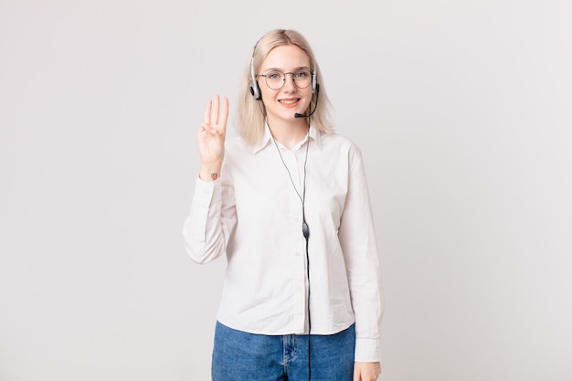 Blonde mooie vrouw die lacht en er vriendelijk uitziet, met nummer drie telemarketingconcept