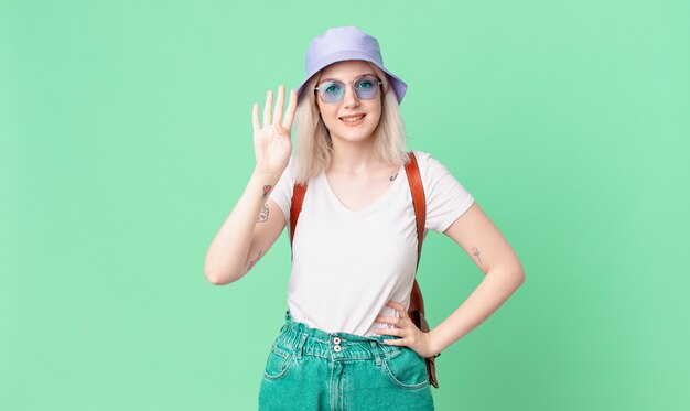 Blonde mooie vrouw die lacht en er vriendelijk uitziet, met nummer vier. zomer concept