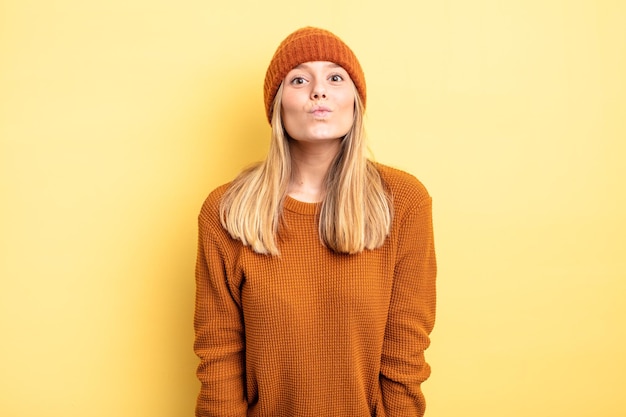 Blonde mooie vrouw die lippen op elkaar drukt met een leuke, vrolijke, mooie uitdrukking die een kus stuurt