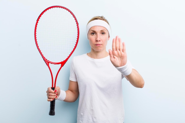 Blonde mooie vrouw die tennissport beoefent