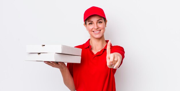 Blonde mooie vrouw die trots en zelfverzekerd glimlacht en het nummer één pizzabezorgingsconcept maakt