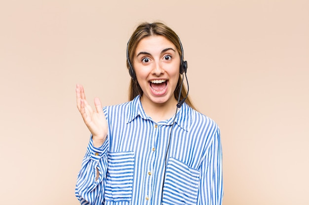 Blonde, mooie vrouw die zich gelukkig, verrast en opgewekt voelt, lacht met een positieve instelling, een oplossing of idee realiseert