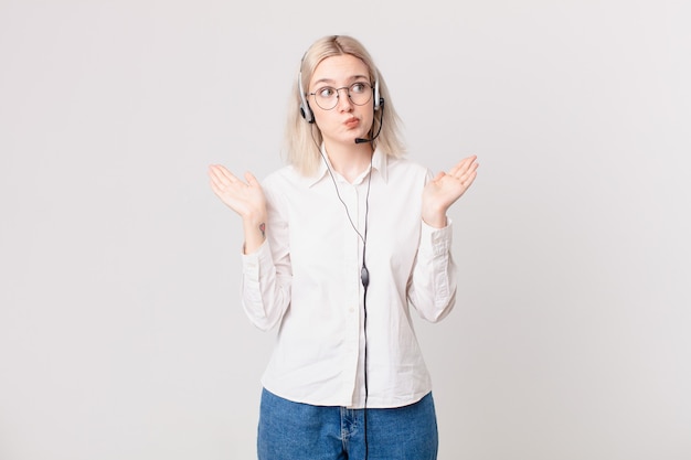 Blonde mooie vrouw die zich verbaasd en verward voelt en twijfelt aan het telemarketingconcept