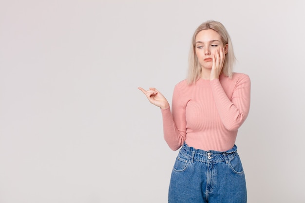 Blonde mooie vrouw die zich verveeld, gefrustreerd en slaperig voelt na een vermoeiende