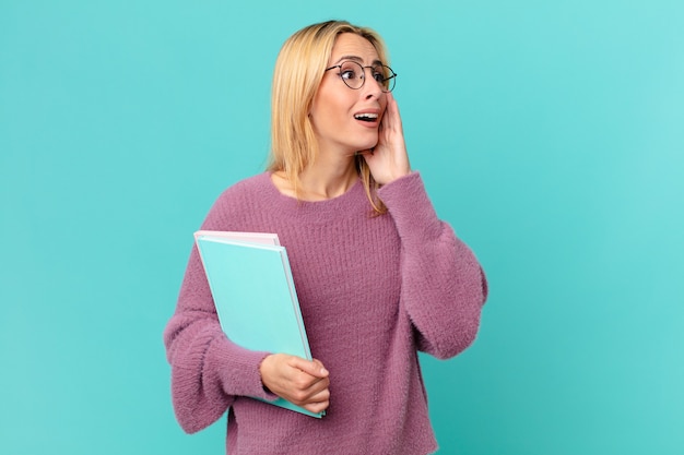 Blonde mooie vrouw met boeken. studentenconcept