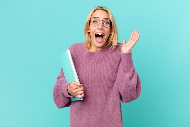 Blonde mooie vrouw met boeken studeren