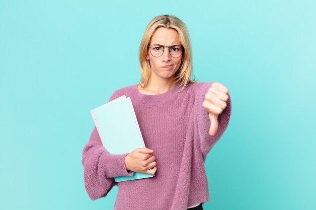 Foto blonde mooie vrouw met boeken studeren