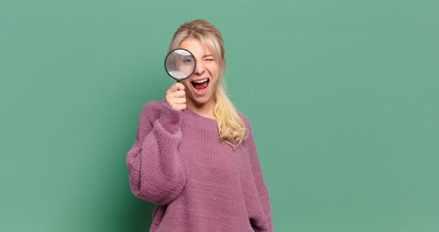 Blonde mooie vrouw met een vergrootglas