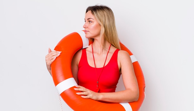 Blonde mooie vrouw op profielmening denkend verbeeldend of dagdromend life guard concept