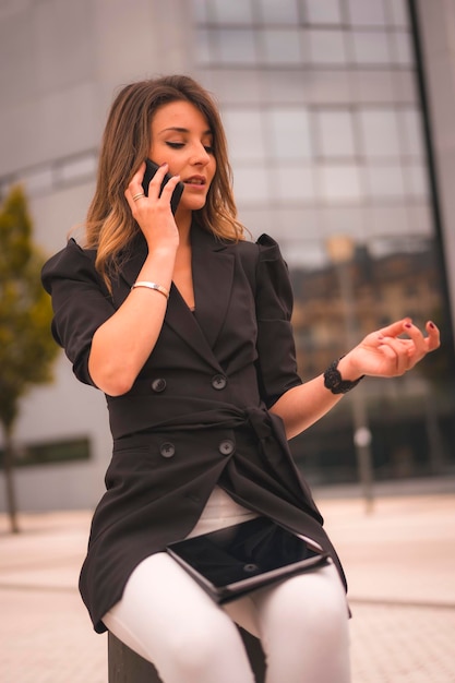 Blonde ondernemer vrouw buiten het kantoor praten aan de telefoon een werk gesprek