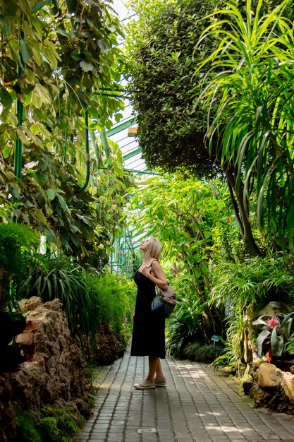 Blonde in the palm greenhouse of the Botanical garden