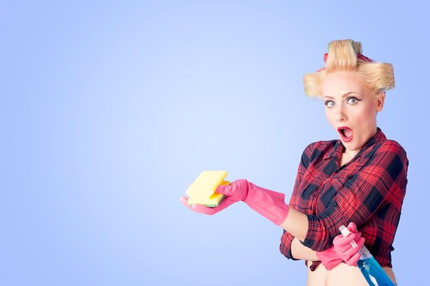 Blonde pin up woman in gloves holding spray bottle