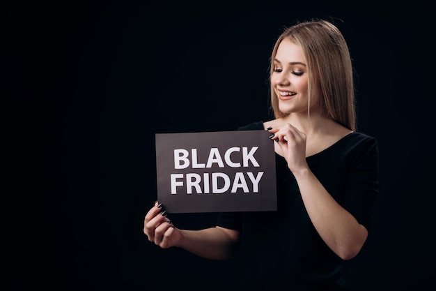 blonde presenting a black friday on card