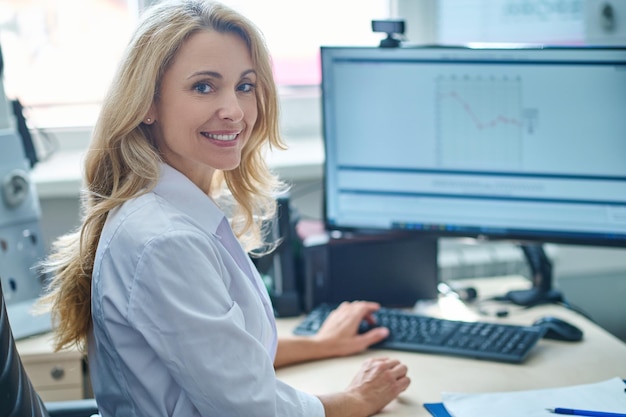 Blonde pretty doctor sitting at her place in the office