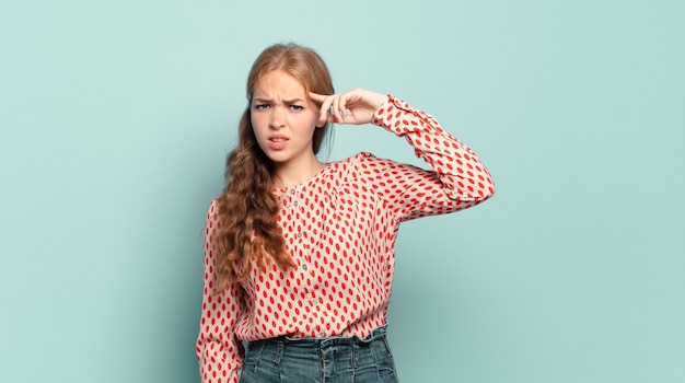 金髪のきれいな女性は、あなたが狂気、狂気、またはあなたの心の外にいることを示して、混乱して困惑している