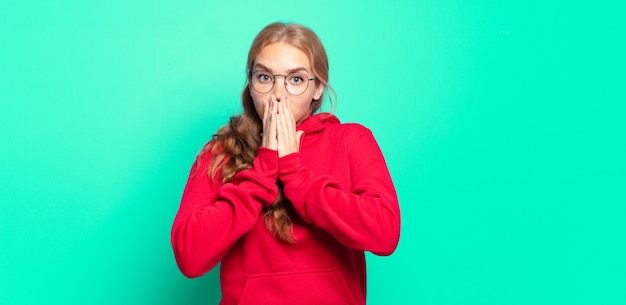 Blonde pretty woman feeling worried, upset and scared, covering mouth with hands, looking anxious and having messed up