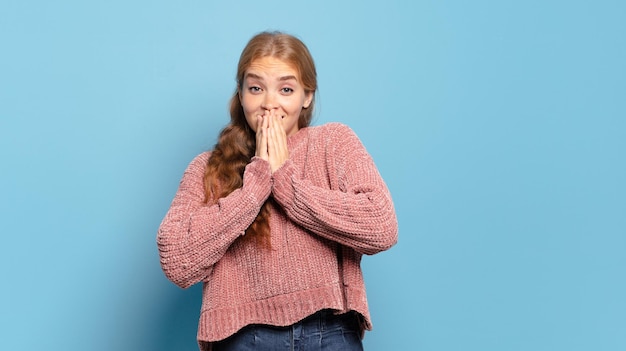 Blonde pretty woman happy and excited, surprised and amazed covering mouth with hands, giggling with a cute expression