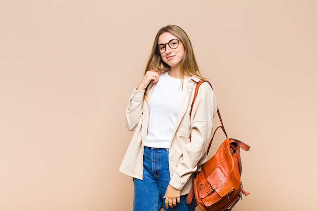 Blonde pretty woman looking arrogant, successful, positive and proud, pointing to self