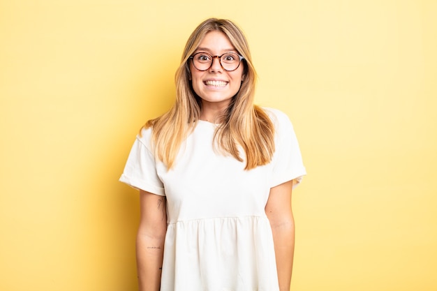 Blonde pretty woman looking happy and goofy with a broad, fun, loony smile and eyes wide open