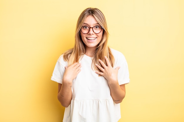 Blonde pretty woman looking happy, surprised, proud and excited, pointing to self