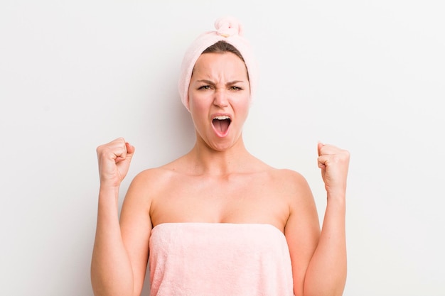 Blonde pretty woman shouting aggressively with an angry expression