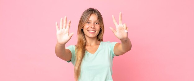 Foto donna graziosa bionda che sorride e che sembra amichevole che mostra il numero otto o ottavo con il conto alla rovescia in avanti della mano