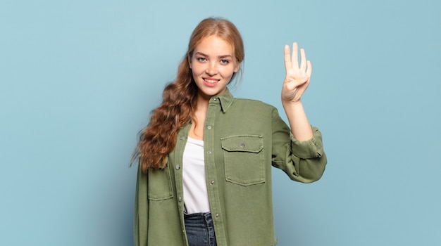 Blonde pretty woman smiling and looking friendly, showing number four or fourth with hand forward, counting down