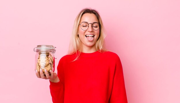 Blonde pretty woman with cheerful and rebellious attitude joking and sticking tongue out cookies concept