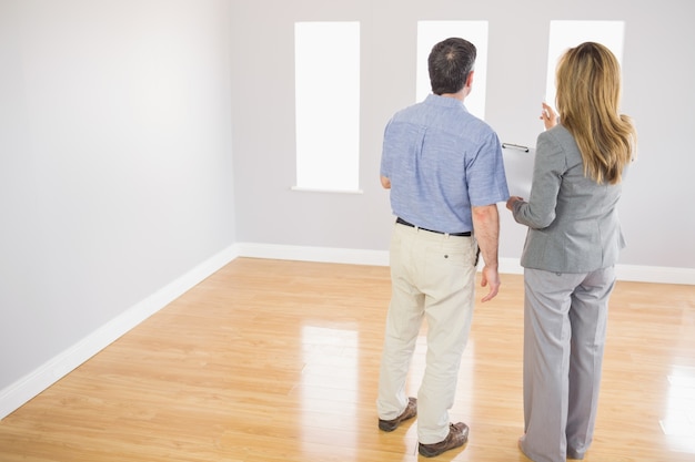 Blonde realtor showing a room to a potential buyer