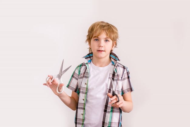 blonde teen boy holding scissors