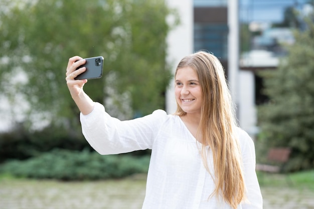 Selfie を取って金髪のティーンエイ ジャーの女の子